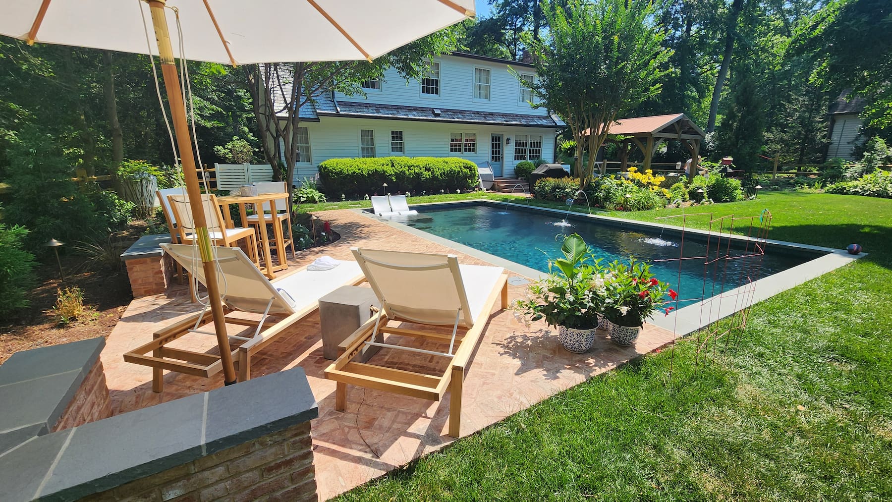 geometric pool with tanning ledge and water features