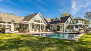beautiful geometric coastal pool with green grass and house in background