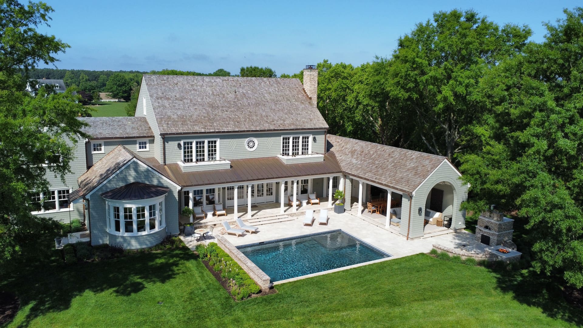 aerial view of geometric pool with water features and fire pit
