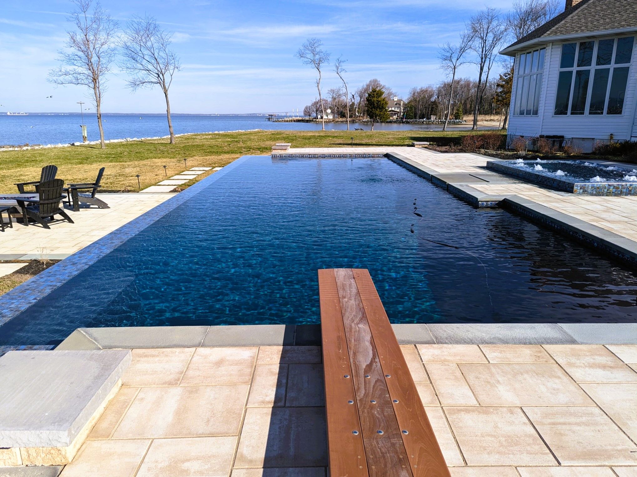 infinity edge pool with diving board near coast