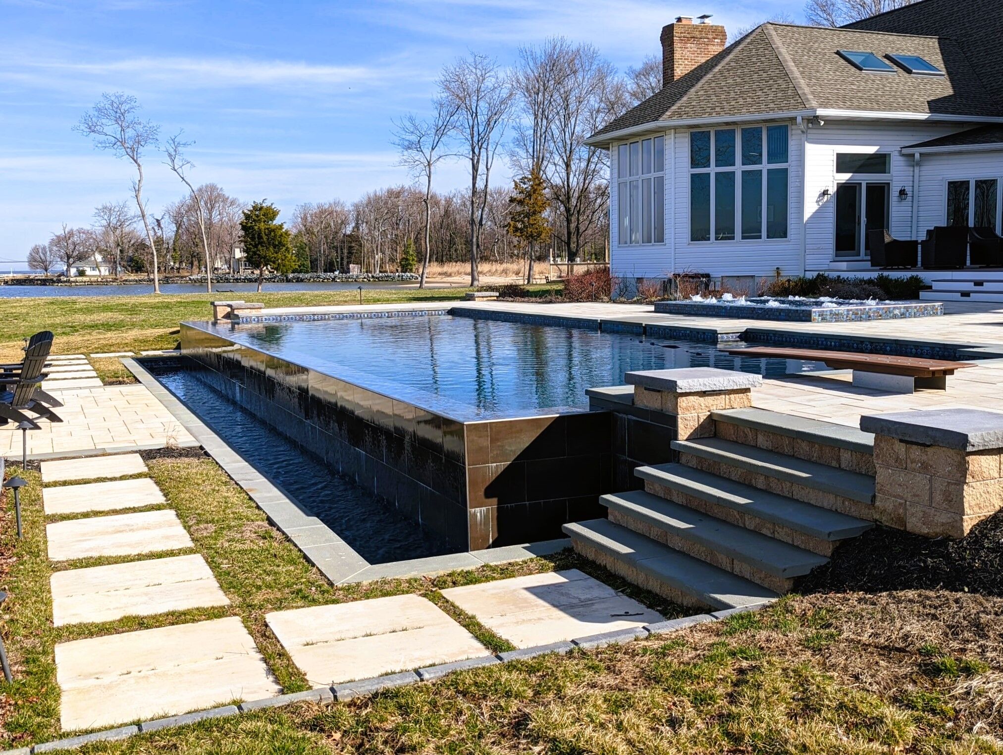 multi-edge infinity edge pool with diving board and detached spa