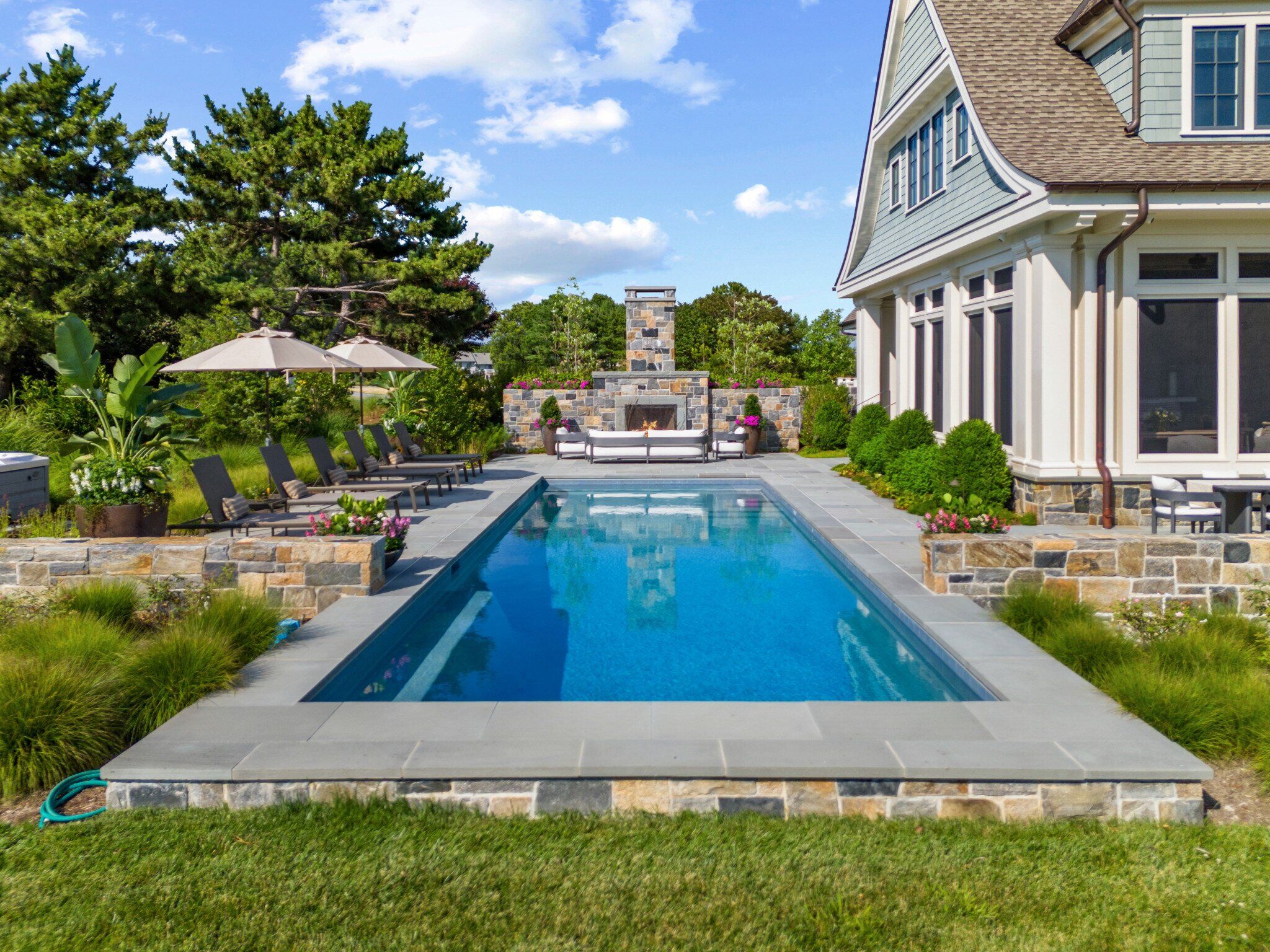 geometric pool with fireplace and outdoor seating area