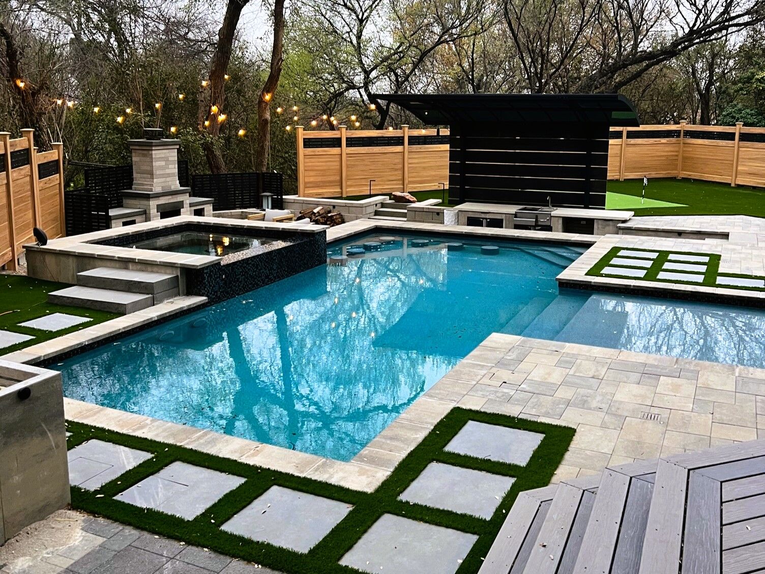 pool with spa and outdoor fireplace and outdoor kitchen