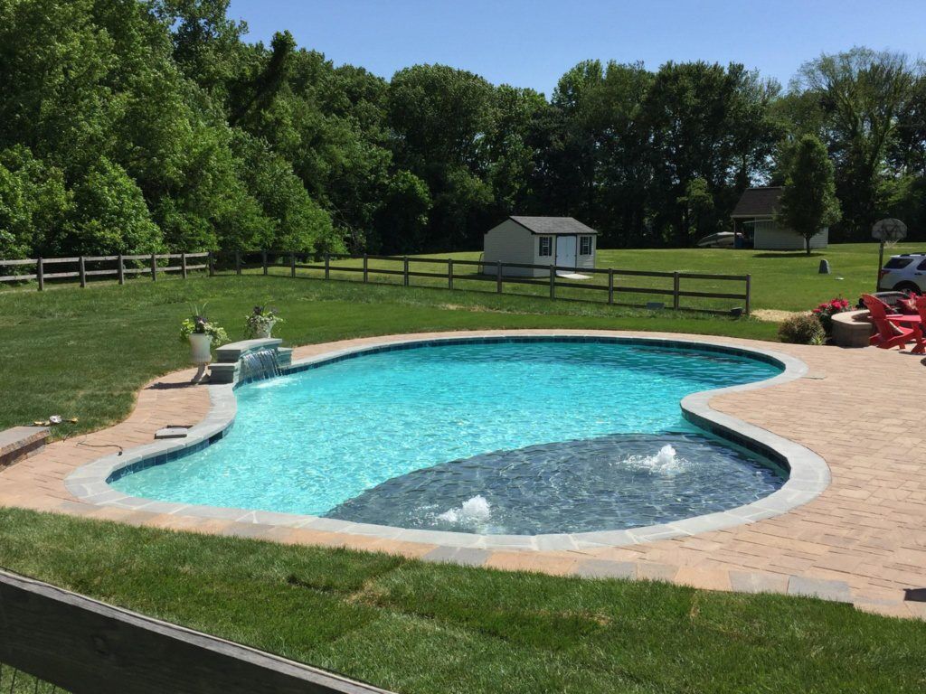 A pool with a custom blue stone tanning ledge in Maryland
