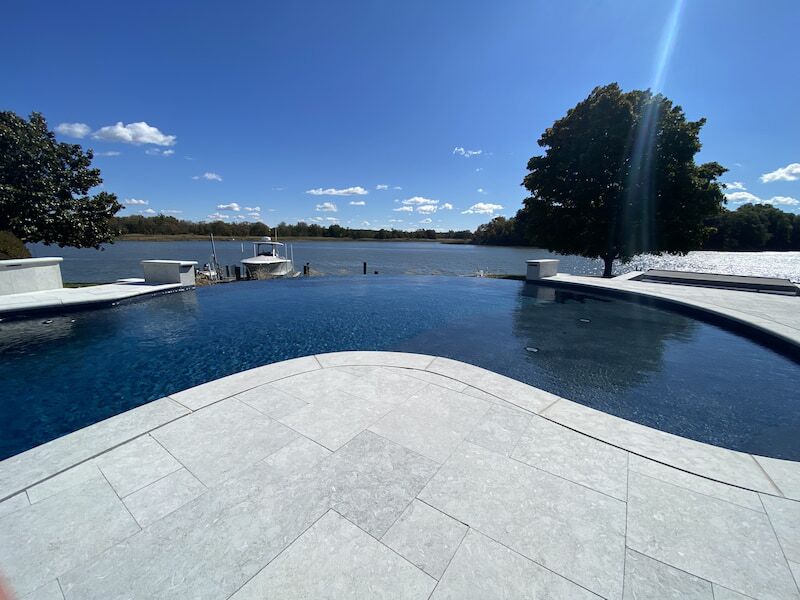 Infinity pool overlooking lake with boat dock