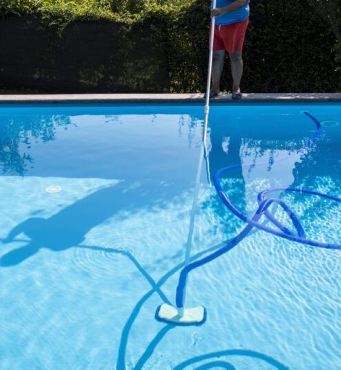 A person cleaning a pool